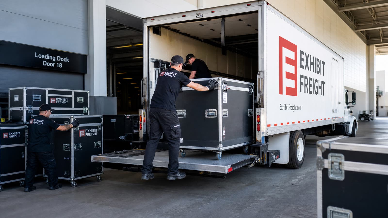 Exhibit logistics team safely loading trade show freight and road cases onto a transport truck